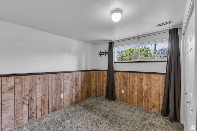 3788 W Hillsboro Cir, West Jordan, UT 84084 - spare room featuring a textured ceiling, wainscoting, visible vents, wood walls, and carpet floors