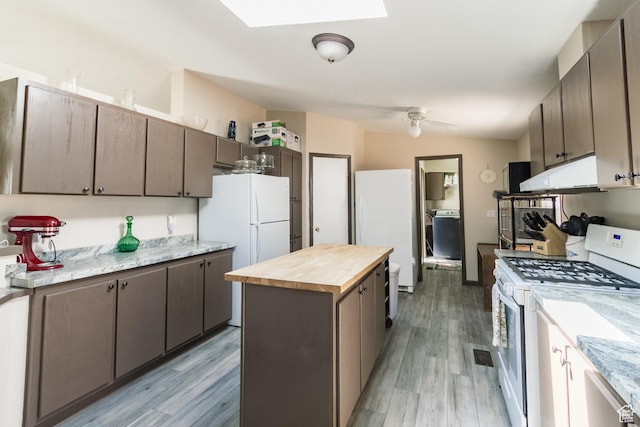 2036 W 1500 N, Vernal, UT 84078 - kitchen with light wood-type flooring, white appliances, under cabinet range hood, a kitchen island, and wooden counters