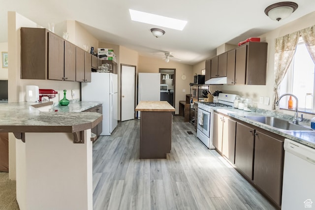 2036 W 1500 N, Vernal, UT 84078 - kitchen featuring under cabinet range hood, a sink, white appliances, a skylight, and a peninsula