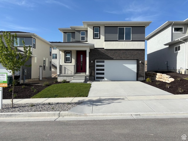 view of front of home featuring driveway, brick siding, and a garage