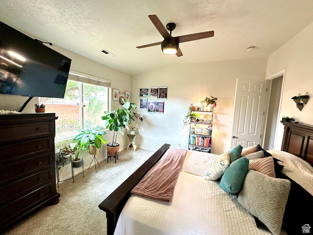 carpeted bedroom with ceiling fan, a textured ceiling, and visible vents