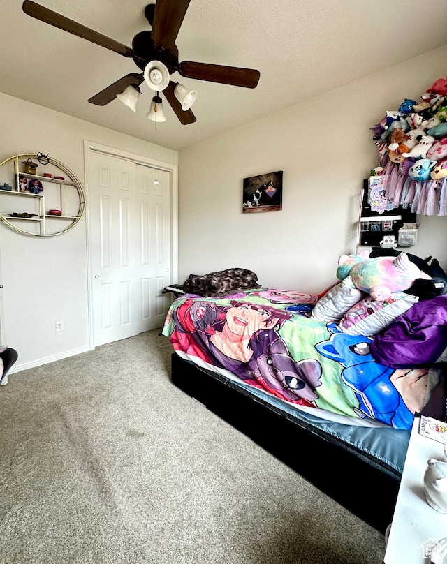 carpeted bedroom featuring ceiling fan, baseboards, and a closet