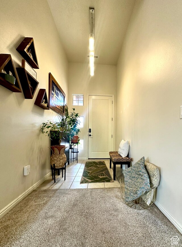 carpeted foyer entrance with baseboards and tile patterned flooring