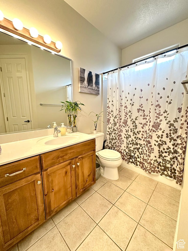 bathroom featuring toilet, a shower with shower curtain, vanity, and tile patterned floors