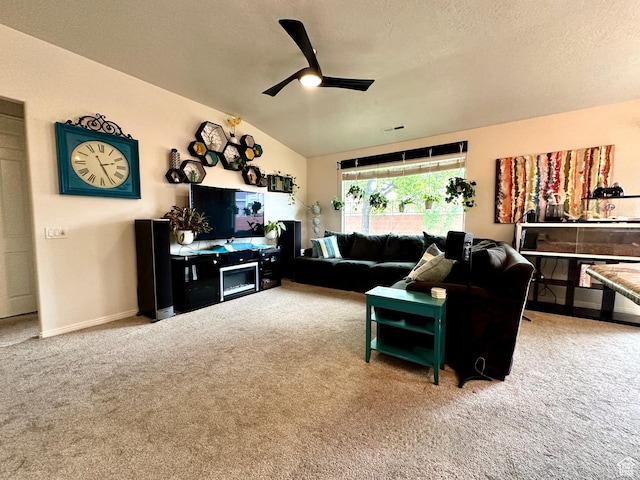 living room with lofted ceiling, a ceiling fan, carpet floors, and a textured ceiling