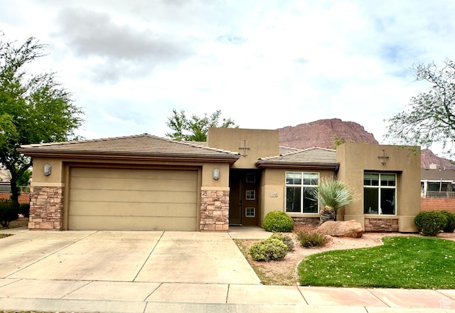 view of front of property featuring a garage, stone siding, concrete driveway, and stucco siding
