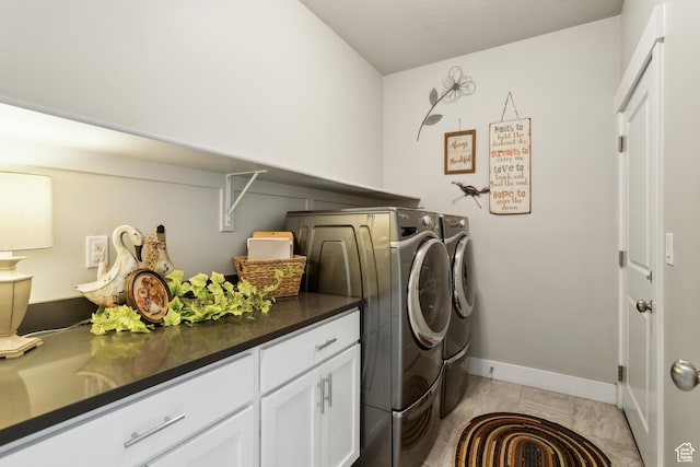 washroom with baseboards, washer and clothes dryer, and laundry area