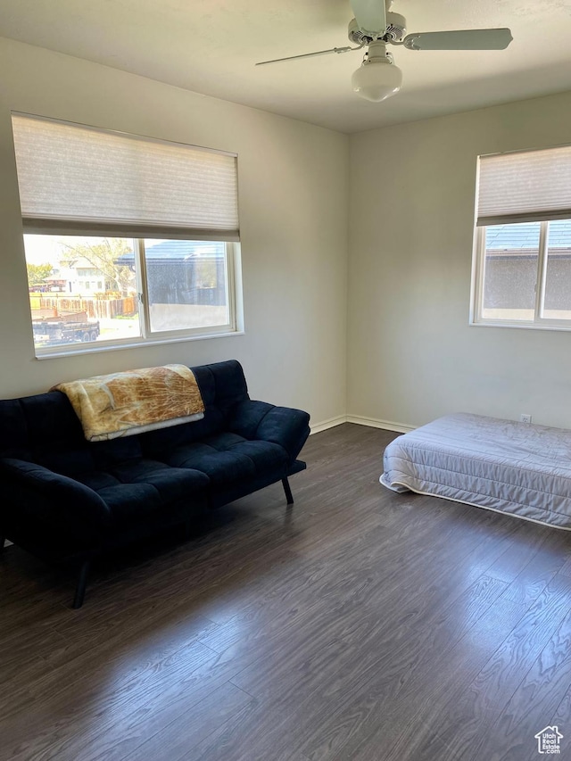 bedroom with baseboards, a ceiling fan, and dark wood-style flooring