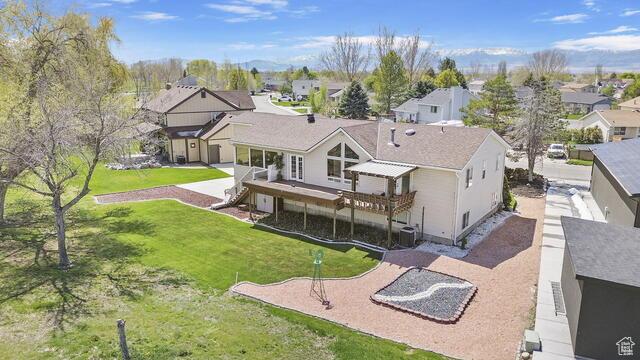 back of property with a yard, a deck, and a residential view