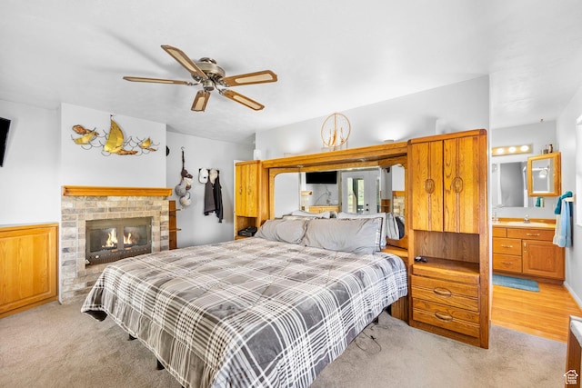 bedroom with light carpet, a sink, and a wainscoted wall