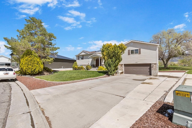 view of front of property with concrete driveway, an attached garage, and a front lawn