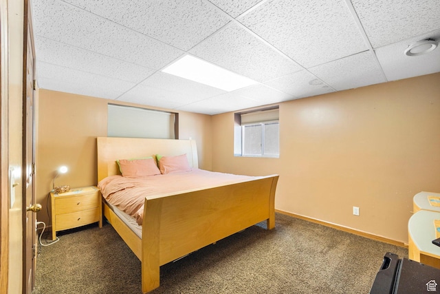 bedroom featuring baseboards, carpet flooring, and a drop ceiling