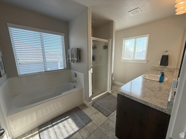 9104 N Cornwall Way E, Eagle Mountain, UT 84005 - full bath featuring vanity, tile patterned floors, a stall shower, a garden tub, and a textured ceiling