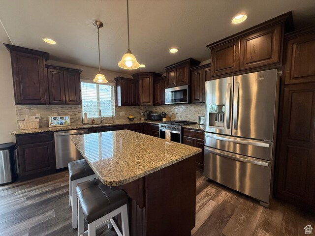 9104 N Cornwall Way E, Eagle Mountain, UT 84005 - kitchen with stainless steel appliances, a sink, dark brown cabinetry, dark wood-style floors, and backsplash