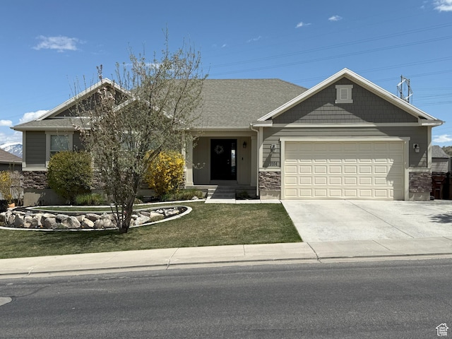 view of front of home with a garage, driveway, stone siding, and a front lawn