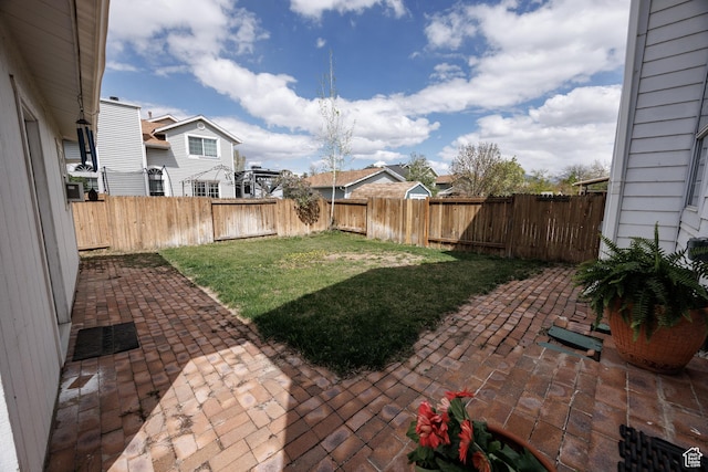 view of yard with a fenced backyard, a residential view, and a patio area