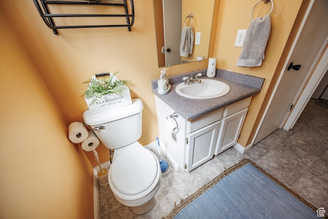 half bath featuring toilet, vanity, tile patterned floors, and baseboards