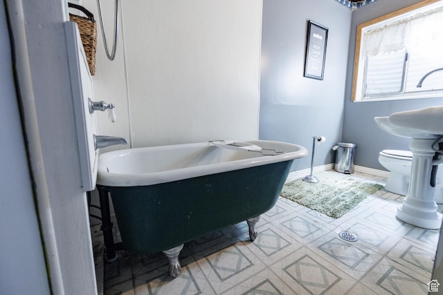 bathroom with a soaking tub and toilet