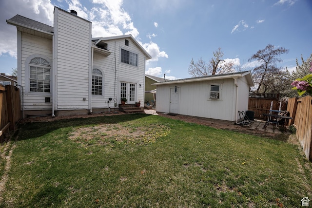 rear view of house with a lawn, a fenced backyard, and a chimney