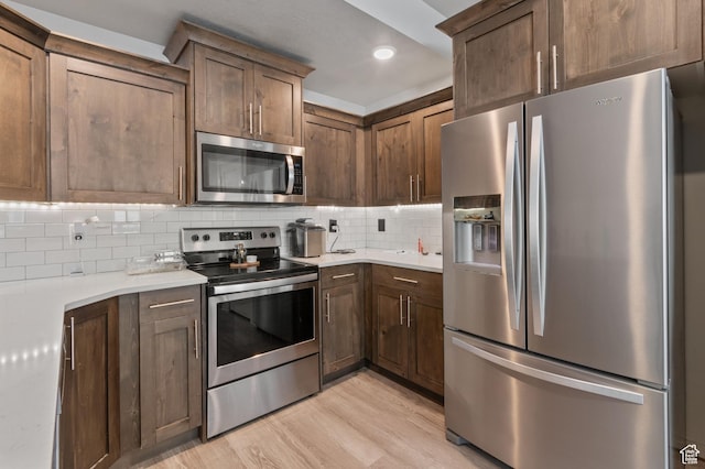 2636 S 2250 W Unit 124, West Haven, UT 84401 - kitchen featuring decorative backsplash, stainless steel appliances, light wood finished floors, and light countertops
