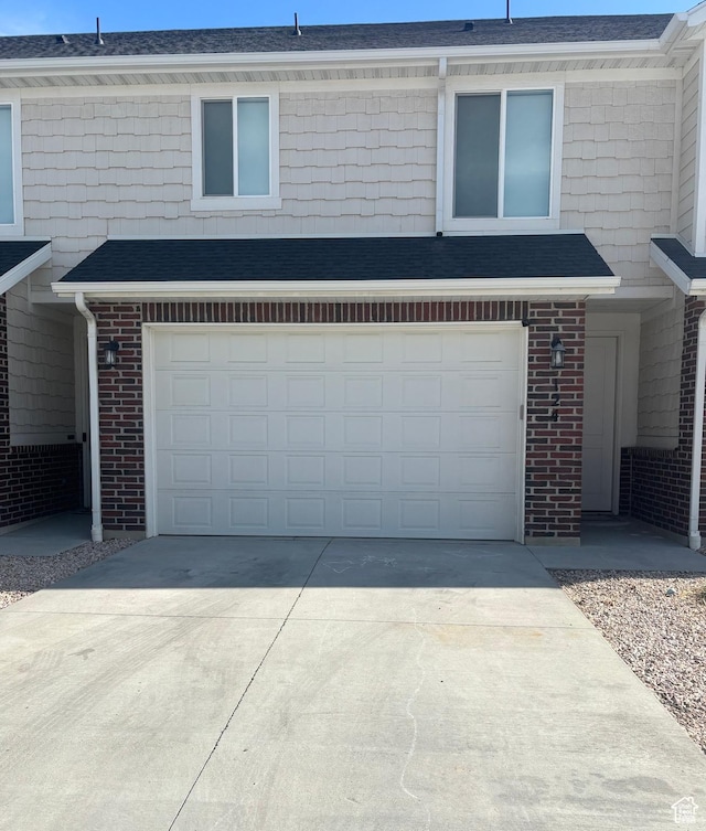 2636 S 2250 W Unit 124, West Haven, UT 84401 - view of front facade featuring a garage, brick siding, and concrete driveway