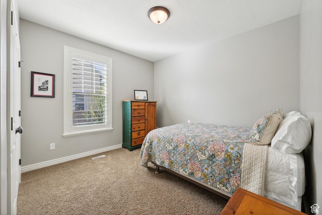carpeted bedroom featuring visible vents and baseboards