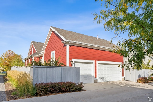 view of property exterior with fence and driveway