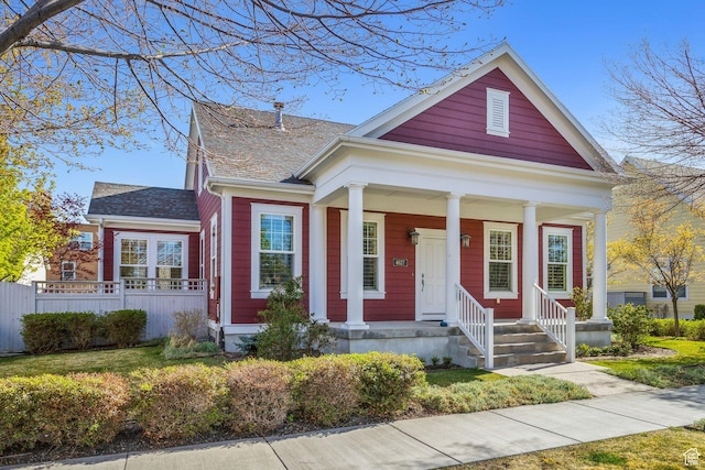 view of front of home with a porch and fence