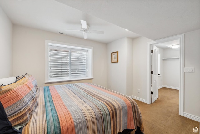 bedroom with carpet flooring, visible vents, baseboards, a spacious closet, and ceiling fan