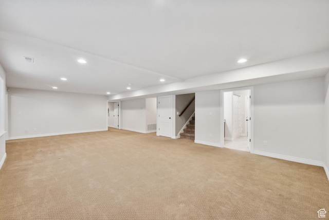 finished basement with recessed lighting, stairway, visible vents, and light carpet