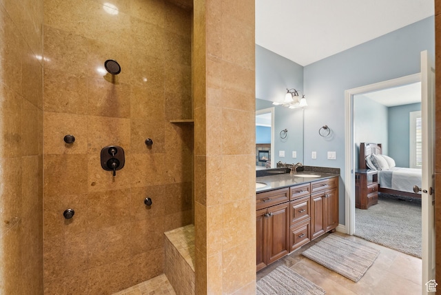 full bathroom with a sink, double vanity, a tile shower, tile patterned flooring, and ensuite bath