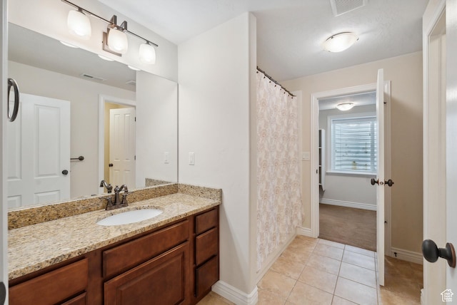 bathroom with tile patterned floors, baseboards, visible vents, and vanity
