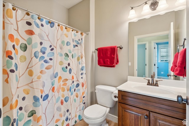 bathroom with toilet, vanity, and a shower with shower curtain