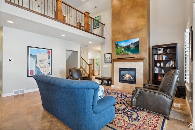 living room featuring stairway, a high ceiling, visible vents, and a fireplace