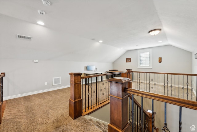 additional living space with vaulted ceiling, visible vents, baseboards, and carpet