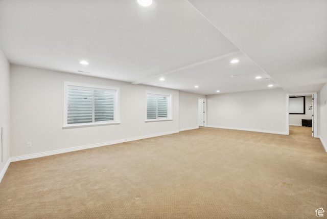 below grade area featuring baseboards, light carpet, and recessed lighting
