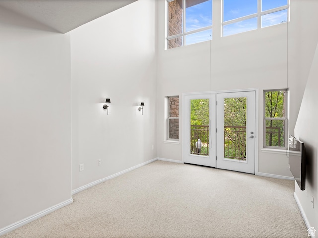 5 S 500 W Unit 311, Salt Lake City, UT 84101 - unfurnished living room with carpet floors, a towering ceiling, and baseboards