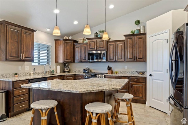 kitchen featuring light tile patterned floors, a breakfast bar area, vaulted ceiling, and black appliances