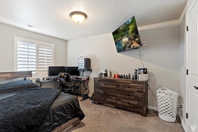 carpeted bedroom with visible vents and a textured ceiling