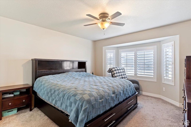 bedroom featuring light colored carpet, baseboards, and a ceiling fan