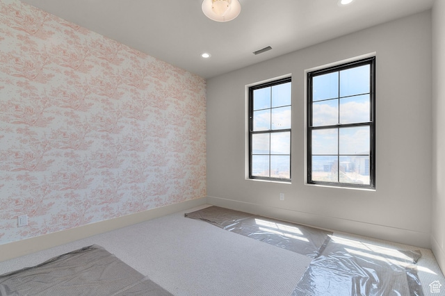 unfurnished room with visible vents, wallpapered walls, baseboards, and recessed lighting