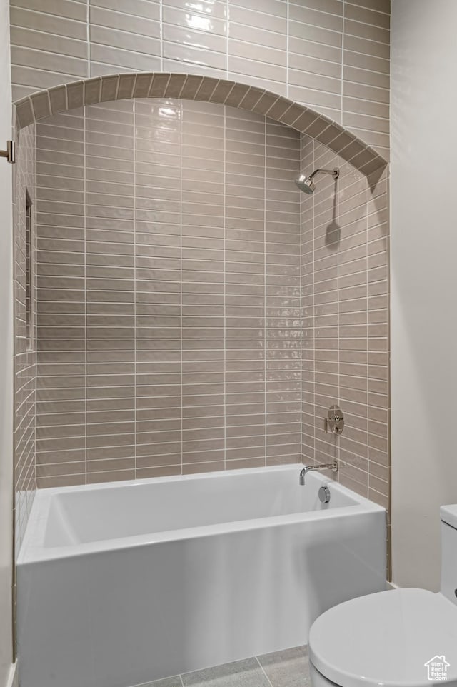 bathroom featuring tub / shower combination and toilet
