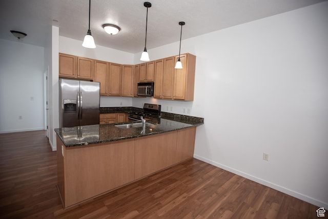 2150 S Main St Unit 514, Salt Lake City, UT 84115 - kitchen featuring a peninsula, dark stone counters, dark wood-style floors, and stainless steel appliances