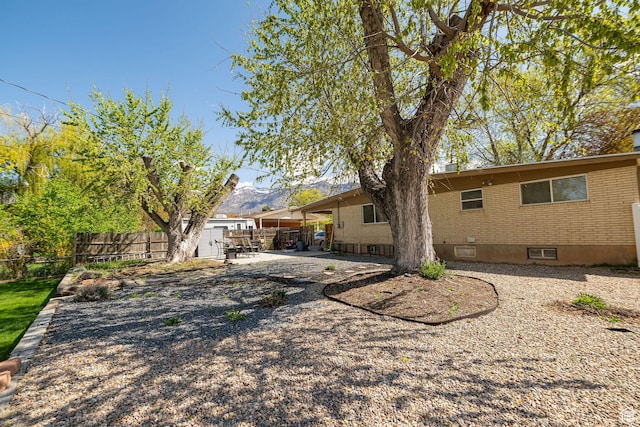 2005 N 500 E, North Ogden, UT 84414 - back of property with fence, brick siding, a mountain view, and a patio