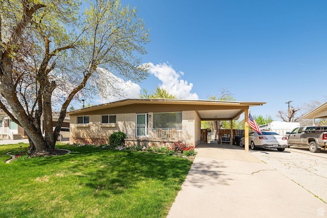view of front facade with brick siding, driveway, a front yard, and an attached carport