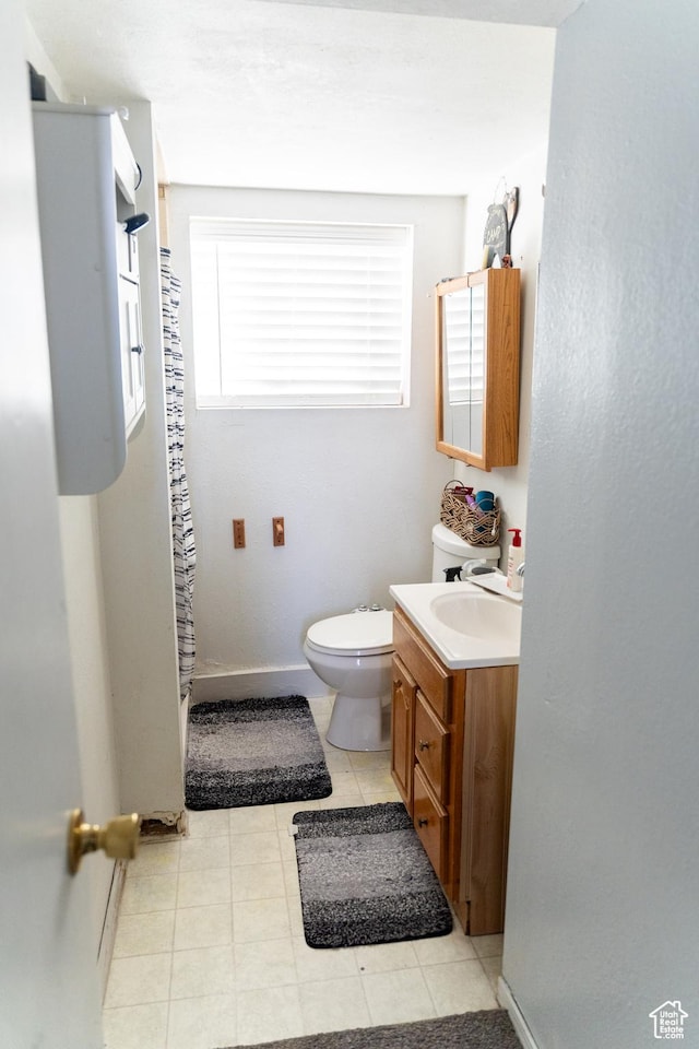 full bath featuring a shower with shower curtain, baseboards, toilet, and vanity