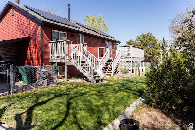 rear view of house featuring a lawn, a fenced backyard, and stairway