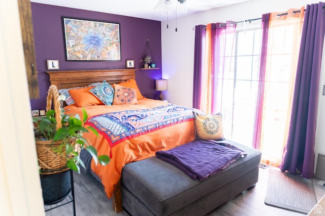 bedroom featuring wood finished floors and multiple windows