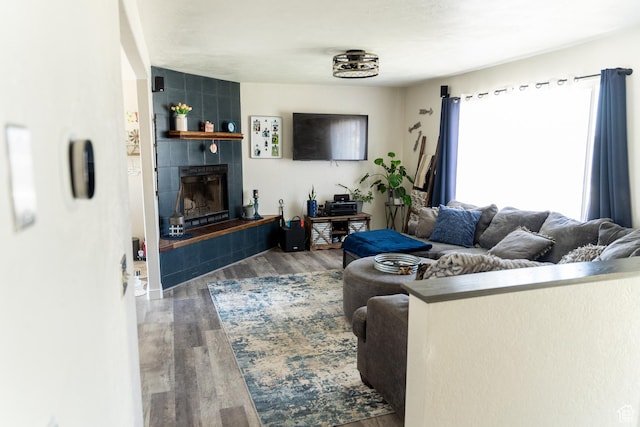 living area with a tile fireplace and wood finished floors