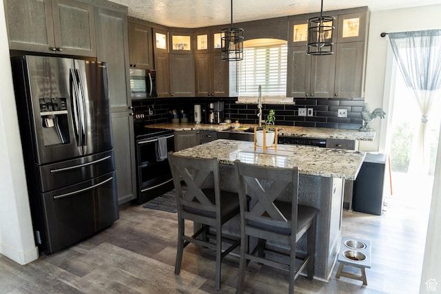 kitchen with decorative backsplash, dark wood-style flooring, stainless steel appliances, and a sink